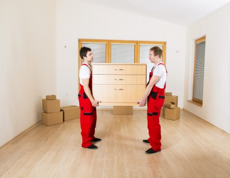 Local removal team handling heavy furniture during a move in southwest London
